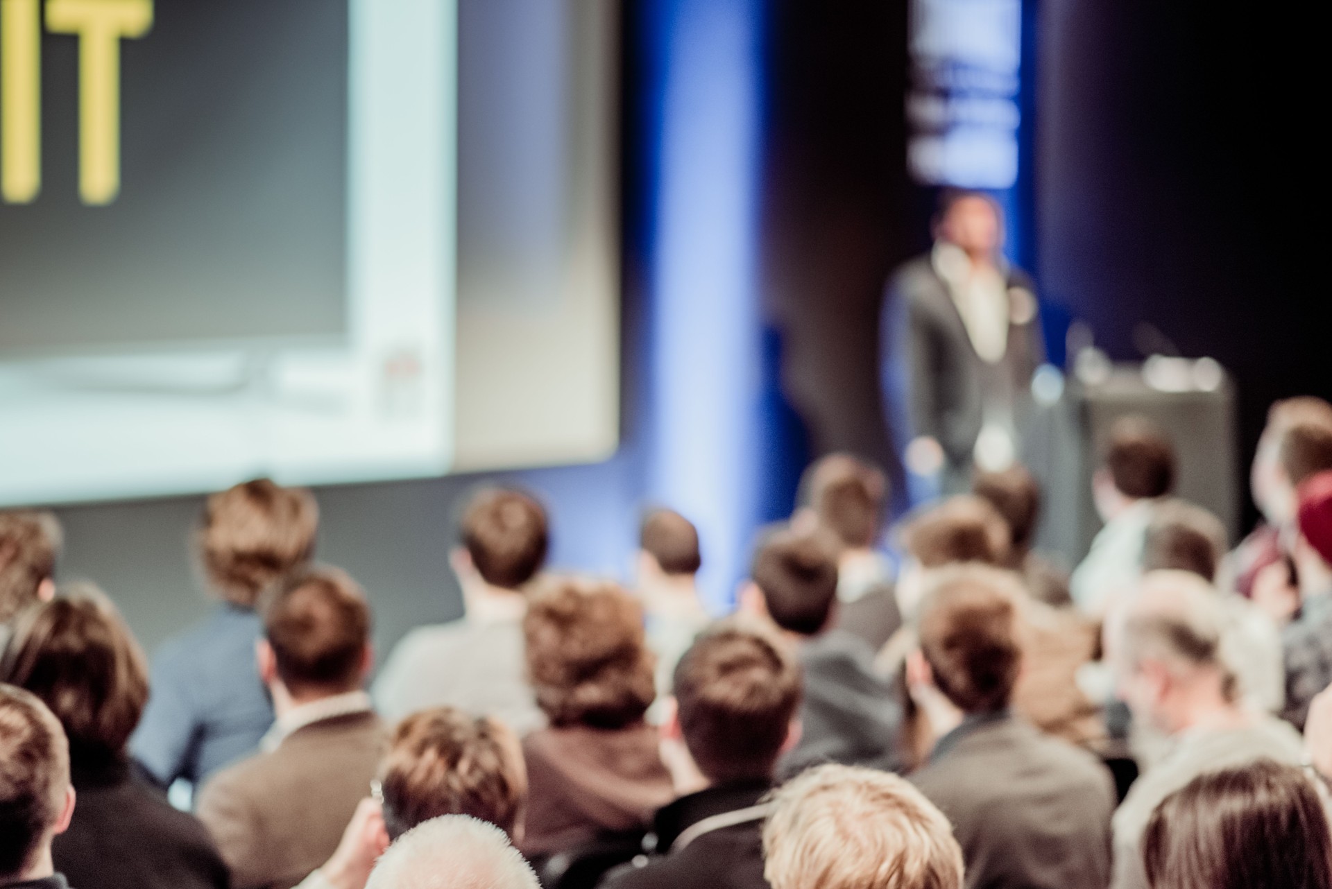 People watching performance of professional on business conference, blurred background